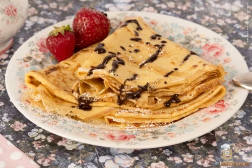 Crêpes mit zwei Erdbeeren und Schokosoße